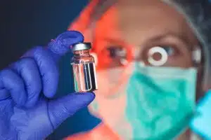 Close up of vial of Flu Vaccine being held by person